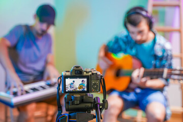 Handsome musicians working at home with his video camera making online concert. Working from home....
