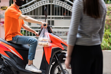 Fototapeta na wymiar Food deliveryman wait customer on motorbike