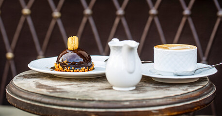 Cappuccino in a cup, hot latte, delicious coffee. Coffe time. Coffee or coffe cup at cafe in the morning. Loving coffee. Cup of fresh cappuccino. Chocolate cake. Closeup. Tasty chocolate cake