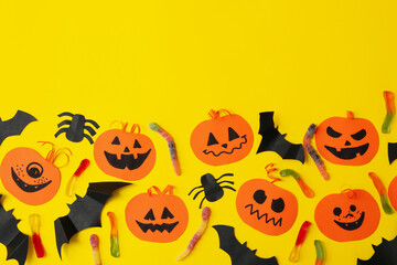 Concept of halloween with paper pumpkins on yellow background