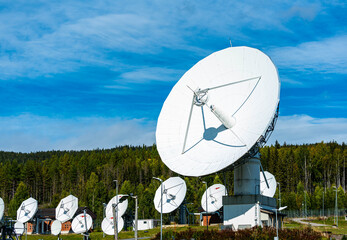 Ground communications station and radio observatory with large white dish antennas. 