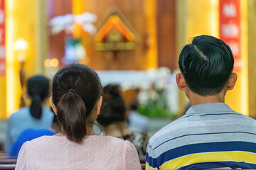 A blurred background photo of the inside of a Vietnamese church sanctuary that is filled with...