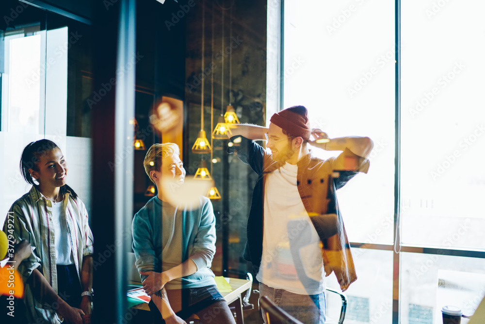Poster group of youthful hipsters enjoying live communication during friendly meeting for brainstorming col