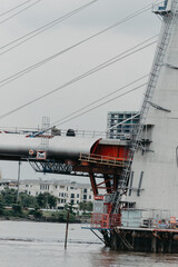 close up of a new cable-stayed bridge is building connecting Thu Thiem peninsula and District 1 across the Saigon River.