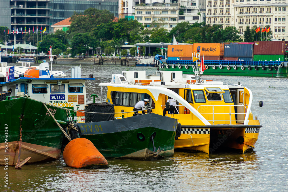 Wall mural Saigon water-bus on the Saigon river and center of Ho Chi Minh city in background