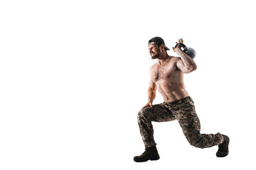 Muscular athlete bodybuilder man in camouflage pants with a naked torso workout with kettlebell on a white background. Isolate