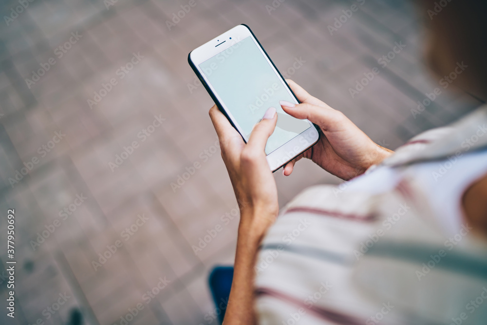 Poster cropped image of female blogger millennial sending text message on mobile phone with blank display w