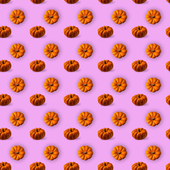 Orange and brown pumpkins on pink background