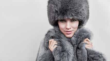 Winter fashion style. Beautiful woman in fur and jewelry. Portrait of young sexy model with beauty makeup