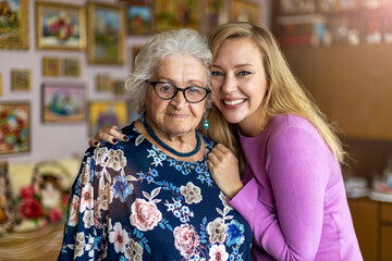 Young woman spending time with her elderly grandmother at home
