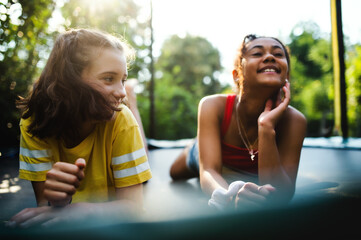 Front view of young teenager girls friends outdoors in garden, laughing.