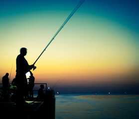 silhouette of fishermen at sunset
