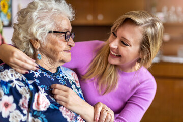 Young woman spending time with her elderly grandmother at home
