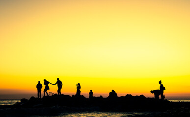 Fototapeta na wymiar people at the sunset rocky shore
