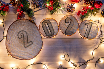 Wooden stump with 2021 happy new year decoration. Round cut down tree with annual rings as a wood texture.