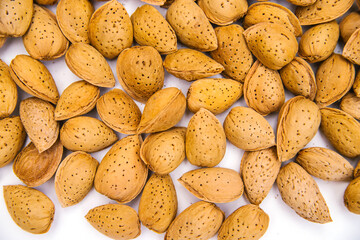 Inshell almonds on a white background. Almonds are laid out as a background .