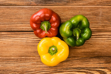top view of colorful ripe bell peppers on wooden table