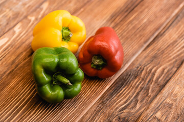 colorful ripe bell peppers on wooden table