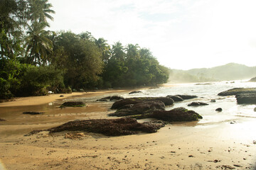 rocky sea beach with crashing waves at morning from flat angle