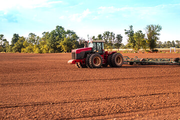 Obraz premium tractor plows the land after harvesting. Preparing for the winter