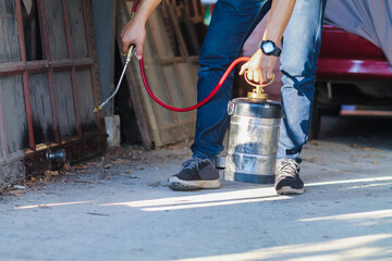 Employees at a termite control company are using a chemical sprayer to get rid of termites at customers' homes and search for termite nests to eradicate them. Chemical spray ideas to prevent insects.