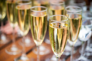 Glasses with golden champagne, bubbles and beautiful bokeh. Alcoholic set to start a party.
