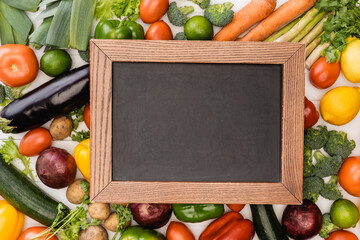 top view of fresh ripe vegetables and fruits near empty chalkboard