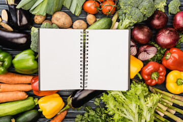 top view of fresh colorful vegetables around empty notebook