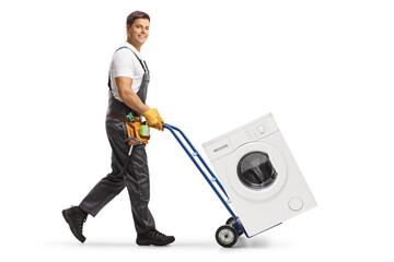 Full length profile shot of a male worker in a uniform pushing a hand-truck with a washing machine
