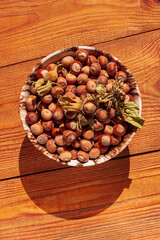 Hazelnuts in porcelain bowl on rustic wooden background. Raw fresh homegrowing nuts from house garden, weight loss diet.