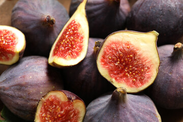 Whole and cut tasty fresh figs as background, closeup