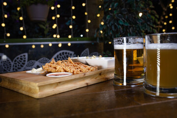 Beer and snack onion rings on wooden table