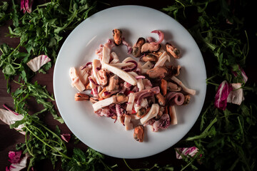 seafood salad on a plate is decorated with lettuce