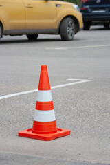 Red signal traffic cone on the background of cars