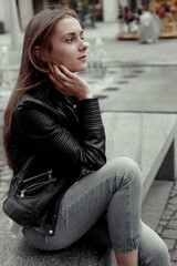 Fototapeta na wymiar Blonde woman sitting on bench and waiting. Profile portrait female model 