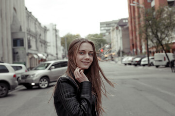 Fototapeta premium portrait of smiling young woman with blond long hair on the street background
