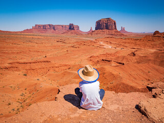 Child with cowboy hat admires panorama from John Ford Point in Oljato Monument Valley, region of...