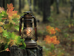 An old kerosene lamp in the autumn forest.
