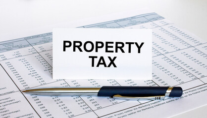 Text Property Tax on white card with blue metal pen on financial table