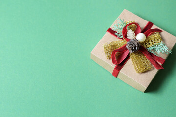 New Year's gift in craft paper on a plain green background.