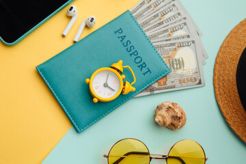 Tourism concept. Sunglasses, smartphone, hat and passport on blue yellow background close-up.