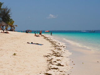 Fototapeta na wymiar Sunny beach day, white sand, blue Indian ocean in Zanzibar island, Tanzania. Copy space for text.