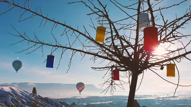 Flying balloons and a tree with colored lanterns.