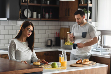 Fototapeta premium Young couple at home kitchen in the morning having relationship problems looking sad