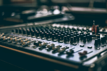 od adjusters and red buttons of a mixing console. It is used for audio signals modifications to...
