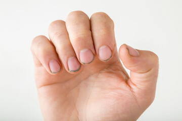Young man hand with dirty nails isolated on light gray background. Closeup.