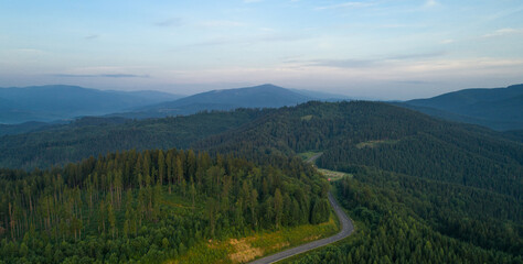 Mountain road. Landscape with rocks, sunny sky with clouds and beautiful asphalt road. Travel background. Highway in mountains. Sunrise mountain beautiful view. fog in the mountains. Aerial view.