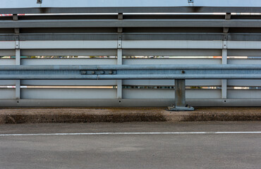 Fence and road railing at a parking lot.