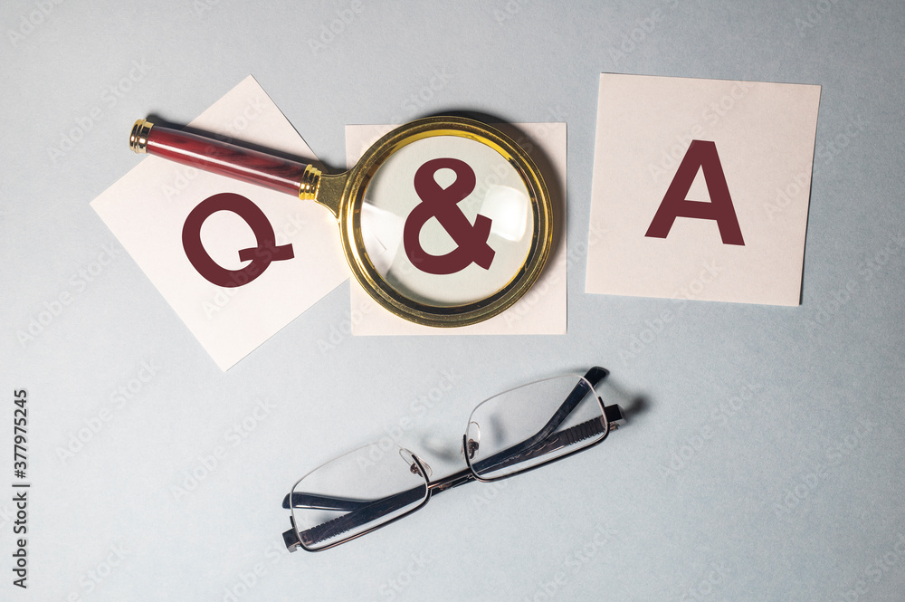 Poster q and a or questions and answers on a piece of white paper on office table. questions and answers co
