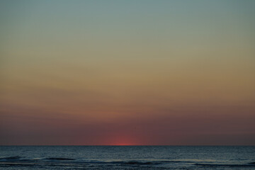 Fototapeta na wymiar Sunset at North Sea Kijkduin Beach in the Netherlands where the land, sea and sky meet